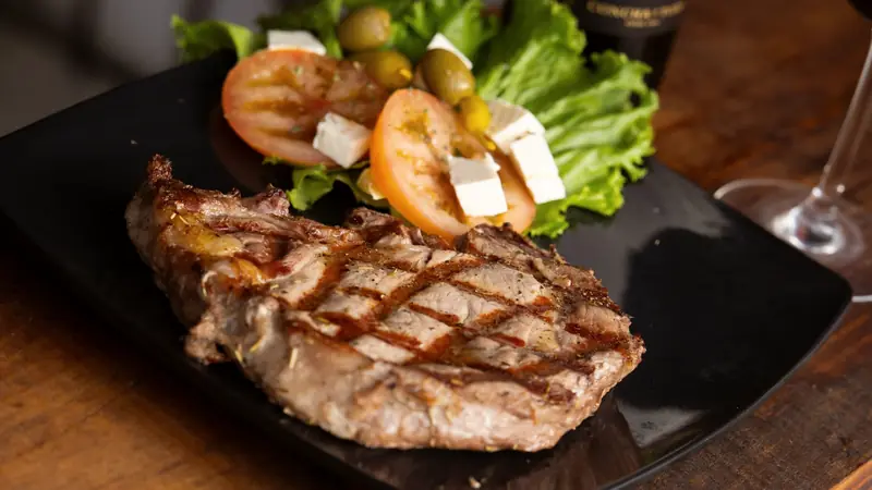 Viande rouge grillée servie avec un verre de vin rouge
