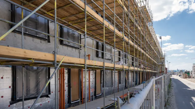 Façade en cours d'isolation derrière un échafaudage
