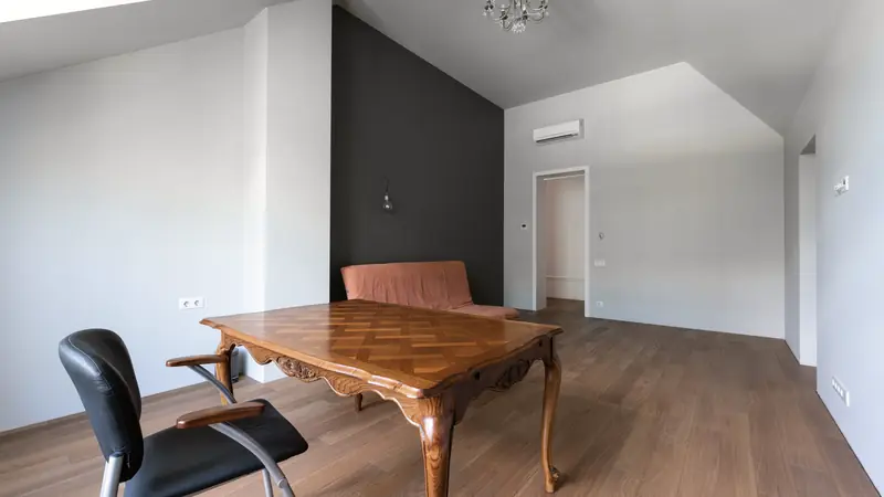 Bureau et canapé installés sous une toiture en pente