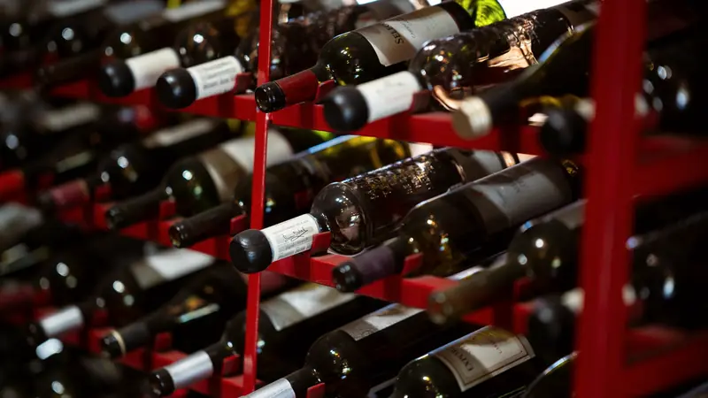 Bouteilles de vin couchées sur un casier métallique rouge