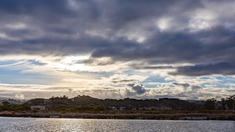 Large étendue d'eau sous un ciel chargé au coucher du soleil