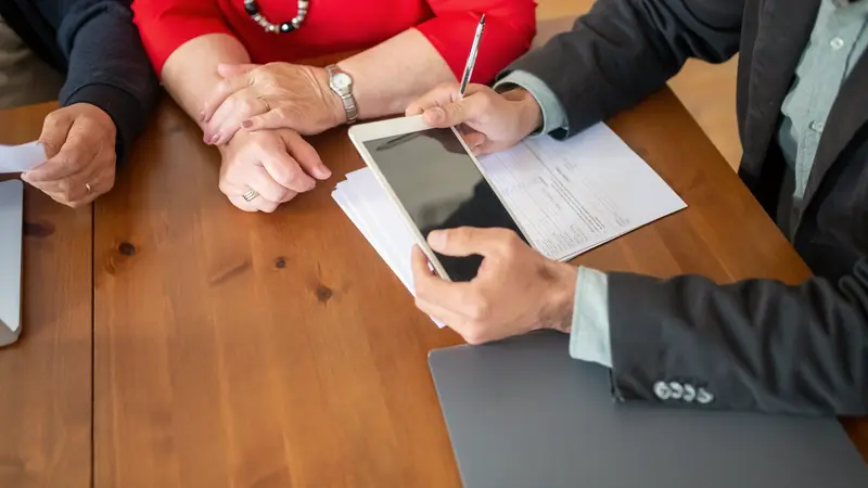 Personne âgée et conseiller examinant des documents à une table