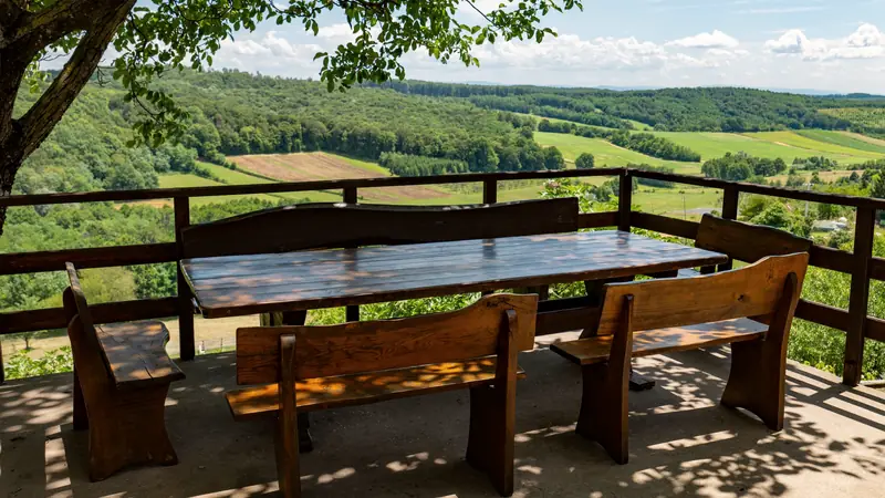 Terrasse en bois avec table et bancs face à la campagne