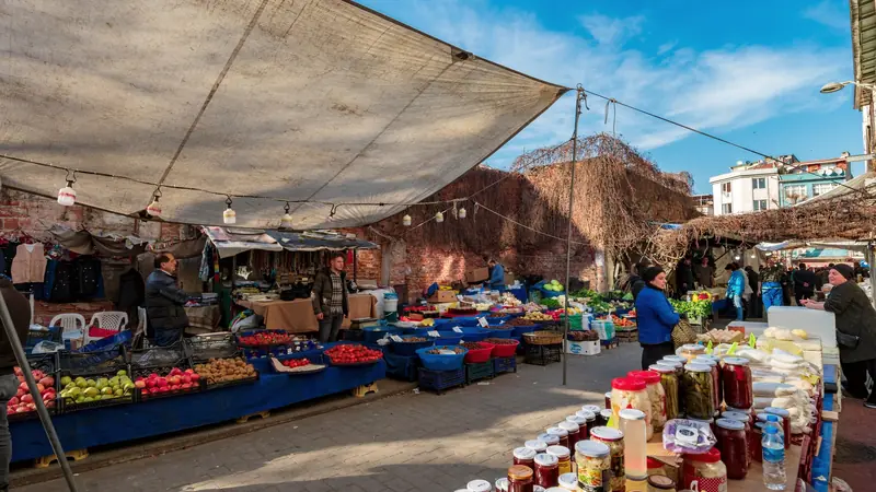 Étals de fruits et légumes sous les toiles d'un marché
