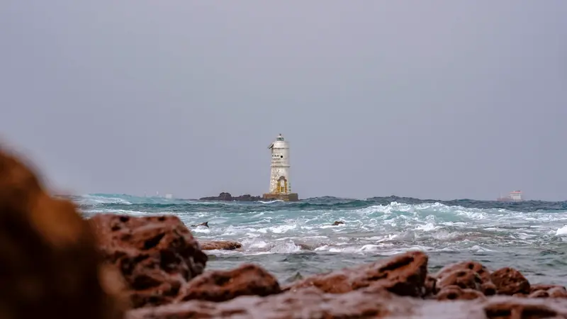 Phare de pierre se dressant en mer au milieu des vagues