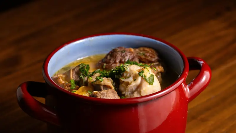 Cocotte émaillée rouge remplie de viande mijotée en sauce