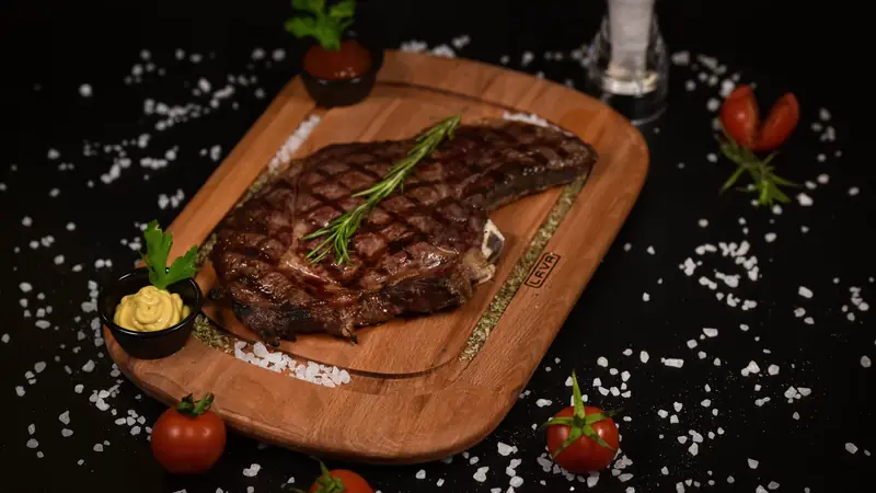 Pièce de bœuf grillée servie sur une planche en bois