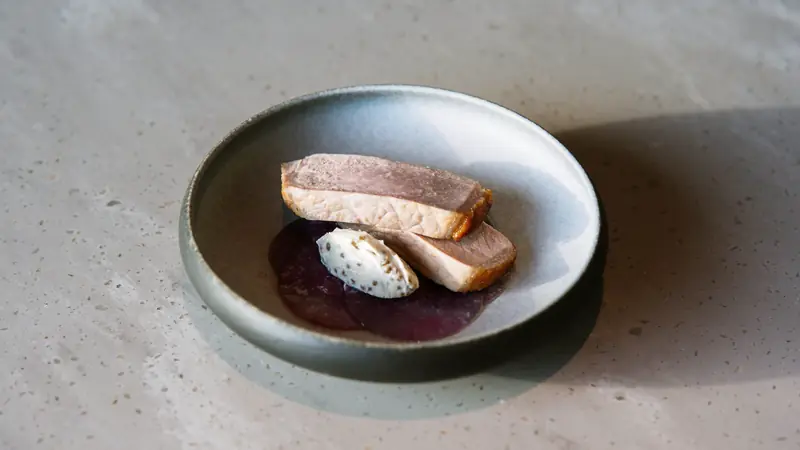 Tranches de foie gras servies avec une sauce dans une assiette en grès