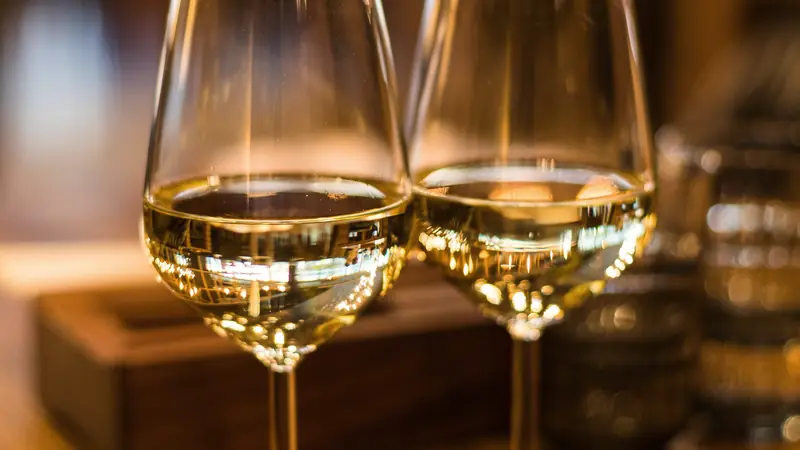 Deux verres de vin blanc dans une lumière chaude de soirée