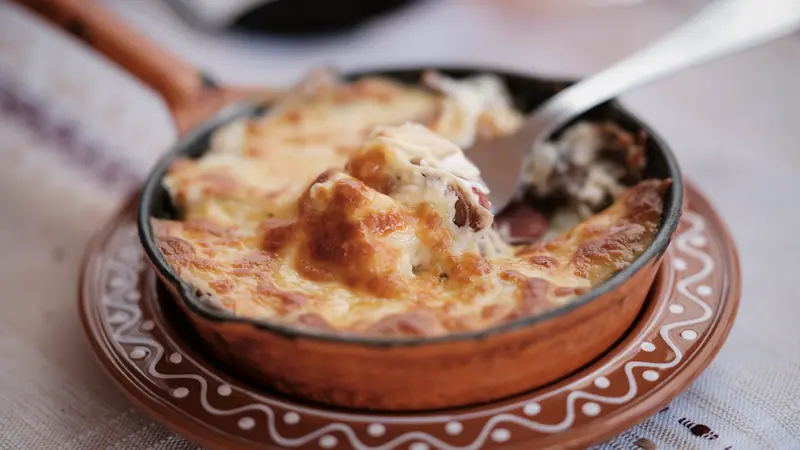 Gratin de pommes de terre au fromage doré, servi dans un plat en terre