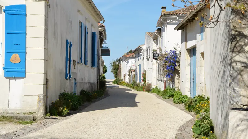 Ruelle bordée de maisons blanches aux volets colorés