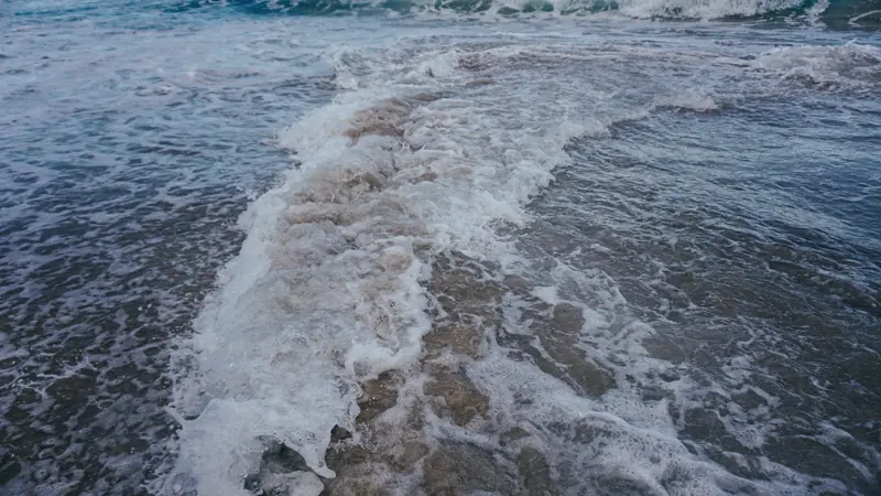 Vagues déferlant sur une plage de sable à marée basse