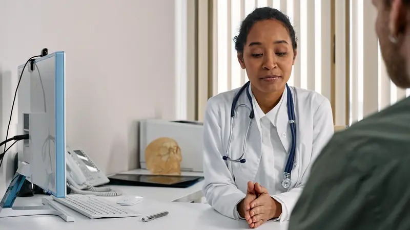 Médecin écoutant un patient dans son cabinet