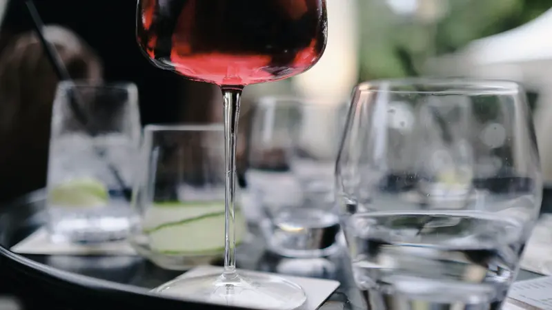 Verre de vin rouge entouré de verres d'eau sur une table