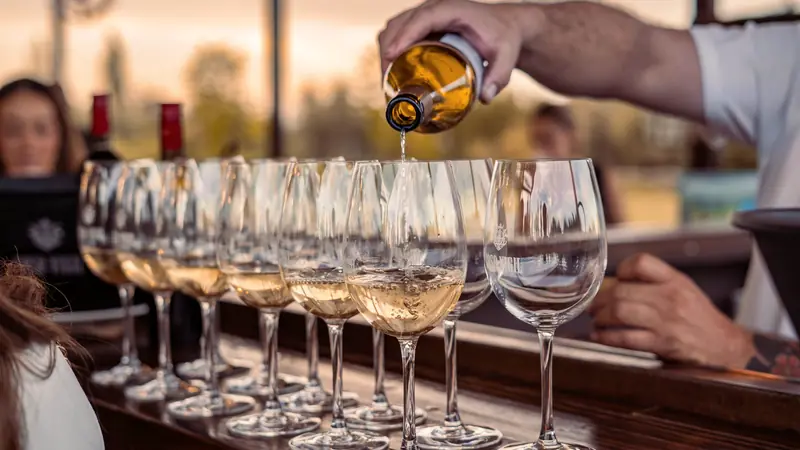 Service de vin dans une rangée de verres alignés sur un comptoir